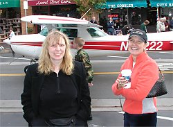 two women standing in front of a plane