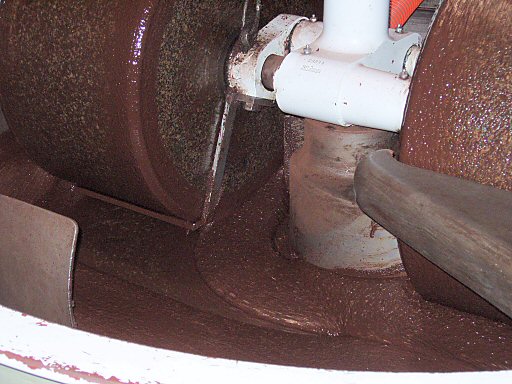close up of melanger wheel crushing cacao into chocolate