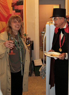 Woman in Mardi Gras beads and man in phantom of the opera costume