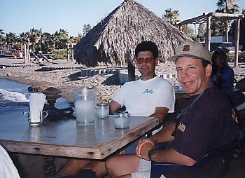 two goofy guys sitting at a table having margaritas