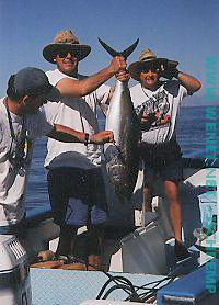 Ron Olivas holding up a tuna he just caught