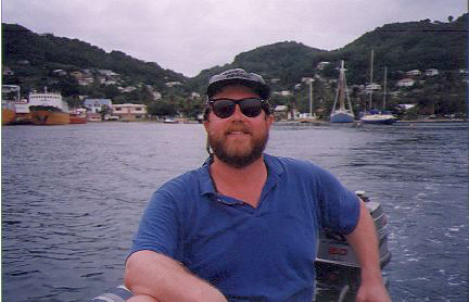 man in a skiff in a harbor in Bequia harbor